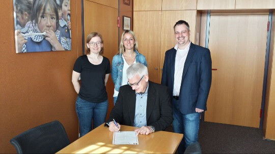 Schulleiter Herr Scheffczyk unterzeichnet den Partnerschaftsvertrag